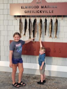 Kids showing off their catches after a Grand Traverse Bay fishing charter trip