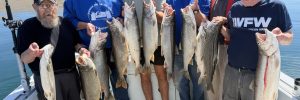 Traverse city fishing charter group holding up their best catches of the day out of Grand Traverse Bay